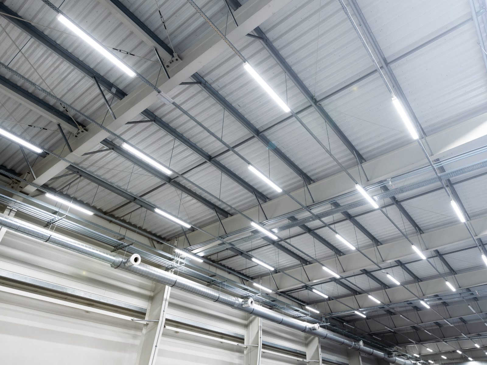 Modern ausgeleuchtete Produktionshalle mit LED-Bandleuchten